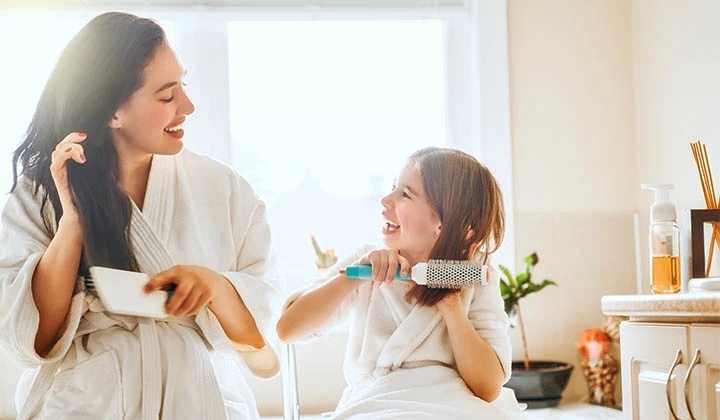 Mutter bürstet der Tochter die Haare Hausmittel bei Läusen gelten als umstritten